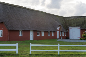 Fototapeta na wymiar Bauernhaus mit weißem Zaun