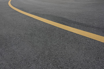 Low angle view of asphalt bend yellow paint line