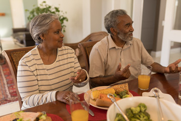 Senior couple sitting together on dining table