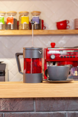 Glass black fruit tea in glass teapot on wooden kitchen background