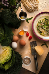 Vegetarian  savoy cabbage pasta with sunflower seeds and oregano  on a wooden board.