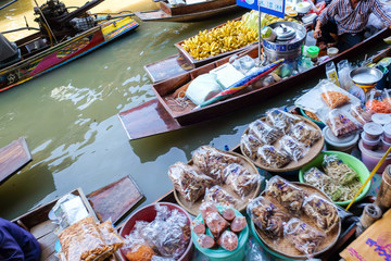 Souvenir and food sell in wooden boat at Damnuensaduag floating travel market