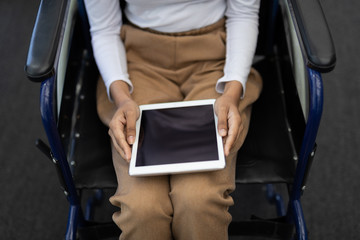 Disabled mixed-race female executive using digital tablet in modern office