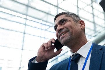 Close-up of Caucasian businessman talking on mobile phone in escalator