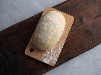The dough lies on a wooden cutting Board. Preparation of pizza dough.