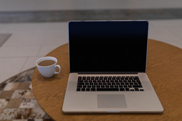 Laptop and cup of tea on a table in the lobby