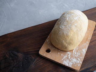 The dough lies on a wooden cutting Board. Preparation of pizza dough.