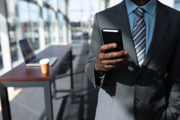 African-American businessman using mobile phone in office