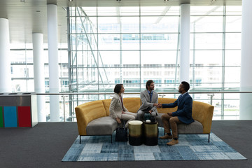 Multi-ethnic business people sitting and discussing with each other in lobby