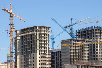 Fototapeta na wymiar Construction site background. Hoisting cranes and new multi-storey buildings. tower crane and unfinished high-rise building. many cranes
