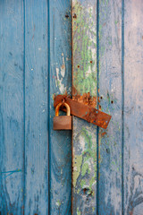 Closeup old rusty lock on the door and broken wood of lock. wood background.