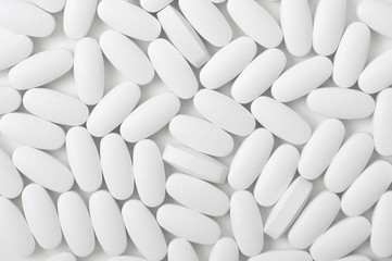 White pills (tablets) background. Top view