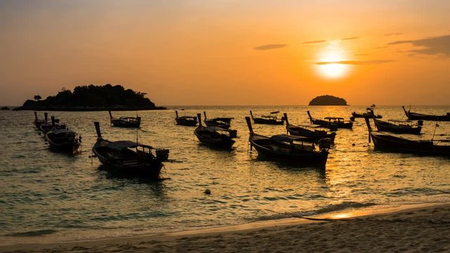 Time-lapse silhouette boats over sea at Koh Lipe during sunrise, sun moving up , PR , Panning Right, Panning.