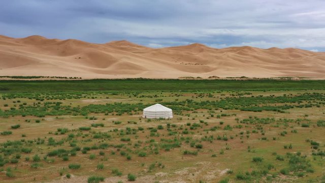 Aerial around view on lonely yurt near the sand dunes in the Gobi Desert, Mongolia, 4k