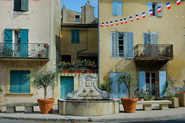Fototapeta na wymiar stone fountain in mediterranean village with provencal building 
