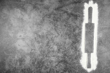 Rolling pin and white flour on a gray background. Free space for text . Flat lay, top view, copy space for your text.