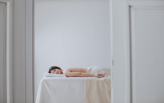 Pretty Caucasian woman lying relaxed on massage table.