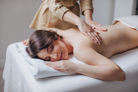 Pretty Caucasian woman enjoying back massage at spa salon.