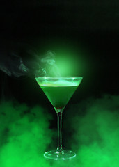 Wineglass with liquor and green smoke
