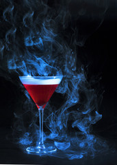 Wineglass with red drink and smoke
