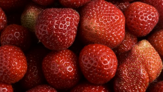 Slow motion rotation of fresh juise strawberries. Top view, Rotation 360 degrees, Extreme close up.  