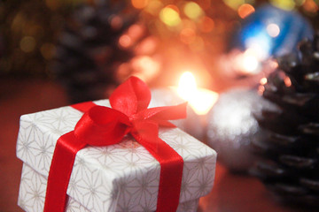 christmas gift box with red bow and candles with new year decor