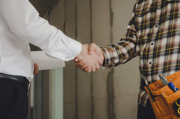 construction worker team contractor shaking hands with engineer after finishing up business meeting to start up project contract in construction site building, teamwork, partnership, industry concept