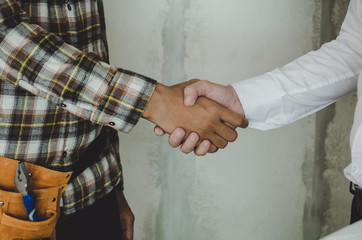 construction worker team contractor hand shake with engineer after finishing up business meeting to start up project contract in construction site building, teamwork, partnership, industry concept
