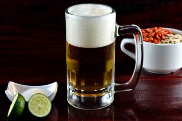 beer accompanied by salt, lemon, peanuts and salted nuggets