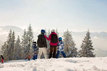 Fototapeta na wymiar Beuatiful family with two kids, skiing on a sunny day in scenery austrian Alps