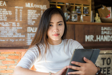 Smart asian business women use tablet sitting in coffee shop