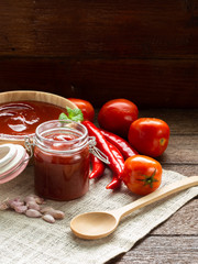 Tomato red sauce in wood bowl and glass bottle with copy space for food issue, recipe or cooking.