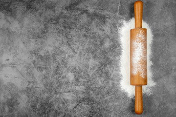 Baking flat lay with rolling pin, flour on gray background. Bake menu, recipe, homemade pastry concept. Top view, with copy space for your text.