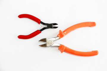 two metal old rusty pliers with red and orange handle