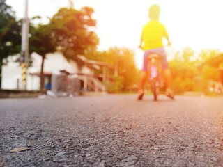 A boy standing with a bicycle in the middle of the road By happily waiting for his father to return home (picture blurred)