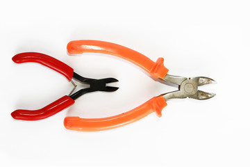 two metal old rusty pliers with red and orange handle
