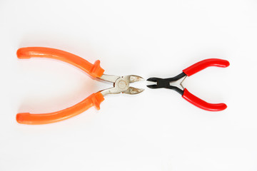 two metal old rusty pliers with red and orange handle