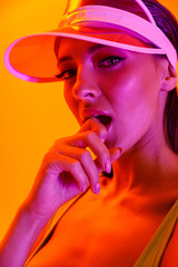Image closeup of seductive sexy woman wearing sun visor cap and sportswear posing at camera
