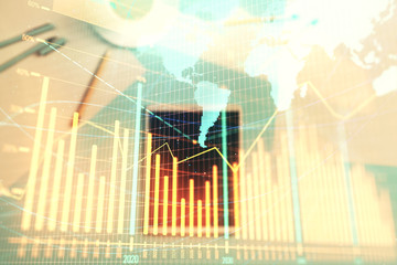 Double exposure of forex chart and world map on digital tablet laying on table background. Concept of market analysis