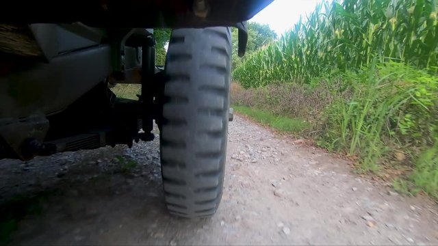 military jeep 4x4 car driving on dirt road, close up of wheel