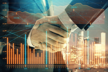 Double exposure of financial chart on cityscape background with two businessmen handshake. Concept of financial analysis and investment opportunities