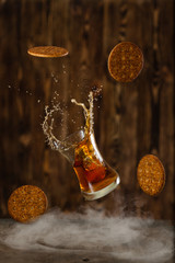 Friday whisky with splash and cookies on a wooden background