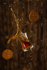 Friday whisky with splash and cookies on a wooden background