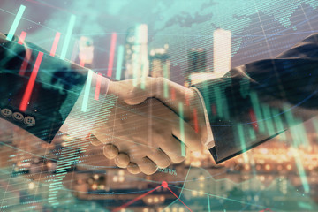 Double exposure of financial chart and world map on cityscape background with two businessmen handshake. Concept of international investment