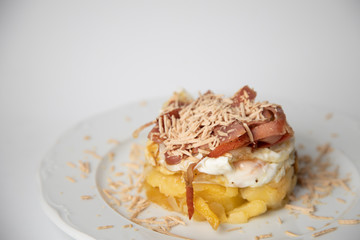 Spanish tapa, potato, fried egg, bacon and foie