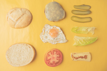 Ingredients for making hamburger on yellow background