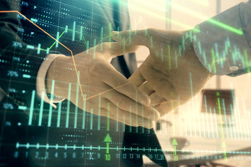 Multi exposure of financial graph on office background with two businessmen handshake. Concept of success in business