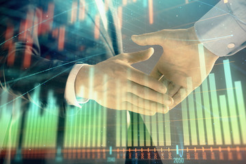 Multi exposure of forex graph on abstract background with two businessmen handshake. Concept of success on stock market