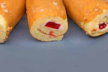 Sponge roll with cream on a gray plate. Calorie foods. Tasty dessert in a cafe.