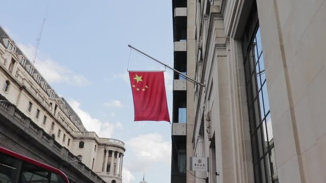 Chinese flag blowing in the breeze in London, with the camera zooming out